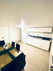 - une cuisine et une salle à manger avec une table et un évier dans l'établissement Logement Proche gare de Villiers le bel, 20 mins de Paris , Stade 2 France, Aéro CDG, Parc des expositions, Disneyland Paris,Futuroscope, Tour Eiffel, à Arnouville-lès-Gonesse