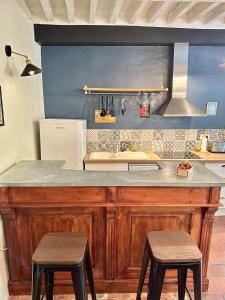 cocina con encimera y 2 taburetes en The Clock Apartment an authentic apartment in the city center, en LʼIsle-sur-la-Sorgue