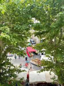una vista aérea de una calle con gente y tiendas de campaña en The Clock Apartment an authentic apartment in the city center, en LʼIsle-sur-la-Sorgue