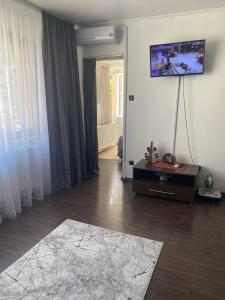 a living room with a television on the wall at Apartament Sory in Băile Herculane