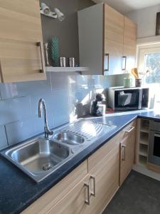 a kitchen with a sink and a microwave at Petit nid doué in Frameries +22 photos