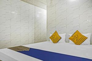 a room with a bed with two yellow pillows at Hotel O Sona in Bhopal