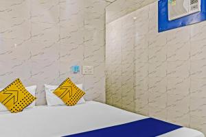 a room with a bed and two yellow pillows at Hotel O Sona in Bhopal