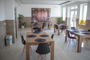 a room with tables and chairs and a painting on the wall at Bárka Vendégház Aggtelek in Aggtelek