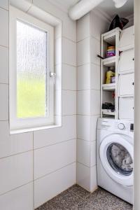 ストックホルムにあるComfortable & spacious villa near Stockholm cityの洗濯機と窓のある洗濯室