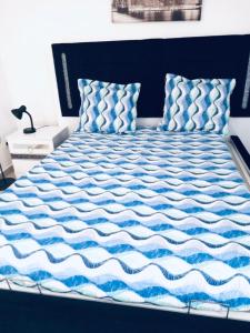 - un lit avec une couette bleue et blanche dans l'établissement Logement Proche gare de Villiers le bel, 20 mins de Paris , Stade 2 France, Aéro CDG, Parc des expositions, Disneyland Paris,Futuroscope, Tour Eiffel, à Arnouville-lès-Gonesse