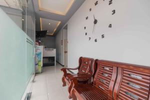 a room with a chair and a clock on the wall at RedDoorz Plus near Millenium ICT Centre Medan 2 in Pulauberayan