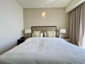 1 cama blanca grande en una habitación con 2 lámparas en JW Marriott Marina Residences, en Dubái 33 fotos más