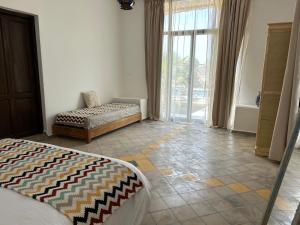 a living room with two beds and a large window at La Perle d'Argan in Essaouira +67 photos