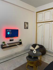 グワーハーティーにあるThe luxe retreatの壁にテレビが取り付けられたリビングルーム