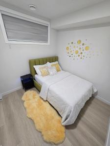 a bedroom with a bed with a rug and a window at Cozy Modern Spacious 2 Bedroom and full kitchen in Southwest Calgary in Calgary
