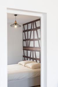 a bedroom with a white bed with a wooden headboard at Alsace in Mulhouse +25 photos