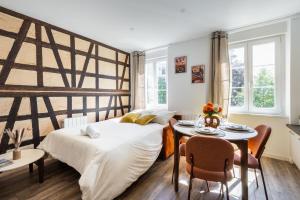 a bedroom with a large bed and a table and chairs at Alsace in Mulhouse
