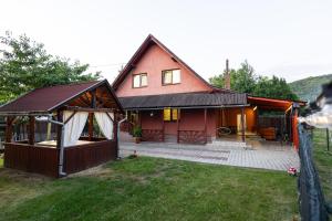 a large red house with a fence in the yard at Gamma in Praid
