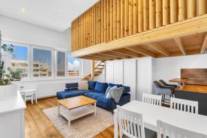 un salon avec un canapé bleu et une table dans l'établissement Sky View Family Apartment, à Trnávka 32 autres photos