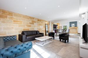 ein Wohnzimmer mit zwei Sofas und einem Fernseher in der Unterkunft L'Ecrin Du Chateau Canon Montségur in Les Salles-de-Castillon