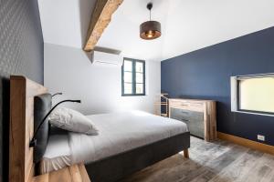 ein Schlafzimmer mit einem Bett und einer blauen Wand in der Unterkunft L'Ecrin Du Chateau Canon Montségur in Les Salles-de-Castillon + 21 Fotos