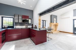 eine Küche mit roten Schränken und einer Arbeitsplatte in der Unterkunft L'Ecrin Du Chateau Canon Montségur in Les Salles-de-Castillon