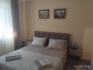 a bedroom with a bed with two towels on it at Prenoćište Lana 3 in Novi Banovci