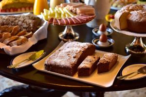 a table filled with different types of cakes and desserts at Pousada Castelo de Obidos in Óbidos