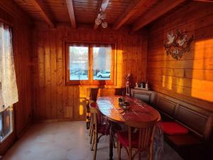 a wooden dining room with a wooden table and chairs at Chalet Le Petit Prince in Saffloz