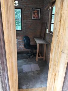 a desk and a chair in a room with a brick wall at Nostalgia Camping Home in Selemadeg +29 photos
