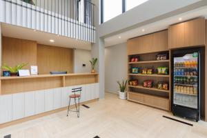 Un restaurante con un refrigerador de bebidas y un taburete. en Urbanview Hotel Puri Indah, en Yakarta