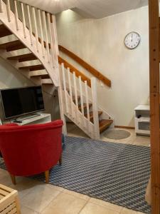 sala de estar con escalera y silla roja en Hiihtäjänkuja 5 A 3 Visit Levi, en Levi