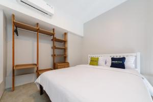 Un dormitorio con una cama blanca y una escalera en Urbanview Hotel Puri Indah, en Yakarta