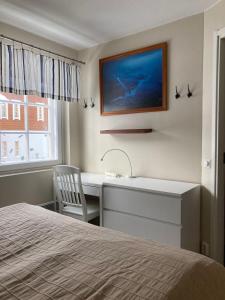 1 dormitorio con escritorio, lavamanos y 1 cama en Hiihtäjänkuja 5 A 3 Visit Levi, en Levi
