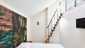 a bedroom with a bed and a large painting on the wall at La Maison Générale in Besançon