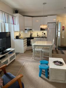 Una cocina y una sala de estar con una mesa y sillas blancas. en Hiihtäjänkuja 5 A 3 Visit Levi, en Levi
