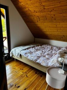 a bed in a room with a wooden ceiling at Malinowa na polu in Skorka