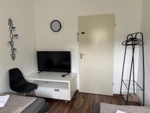a bedroom with a tv and a desk with a chair at Main Weindorf Unterkunft in Sulzfeld am Main