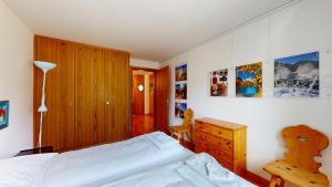 1 dormitorio con 1 cama, vestidor y escritorio en Splendura 4, en Silvaplana