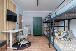 ウッチにあるTeofilów Residenceの二段ベッド2台、デスクが備わるドミトリールームです。 +2枚の写真