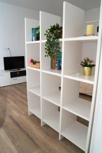 a white book shelf with plants in a living room at Piso Acogedor a Metros de la Plaza de las Flores in Murcia +4 photos