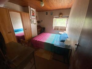 a small room with a bed with a colorful blanket at Maison Goexenia Etcharry 2 chambres in Etcharry
