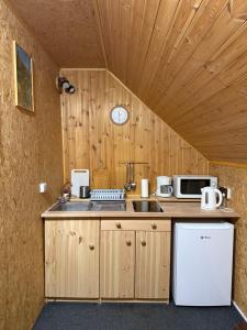a kitchen with a counter with a sink and a clock at Pension U Krtka - přímo u sjezdovky in Harrachov