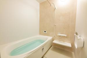 a bathroom with a bath tub and a shower at Irodori Hotel KAZE in Fukuoka