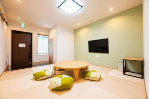 a living room with a table and a television at Irodori Hotel KAZE in Fukuoka +29 photos