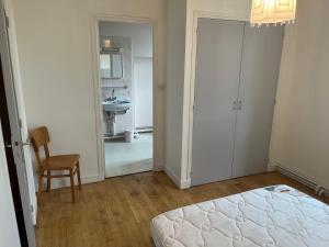 1 dormitorio con 1 cama y 1 silla y baño en Duplex, en Mur-de-Barrez
