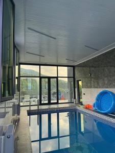a swimming pool in a house with a large window at Harmony Escape in İsmayıllı