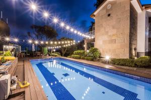 a swimming pool in front of a building at night at Monaco Pool Pension in Seogwipo +89 photos