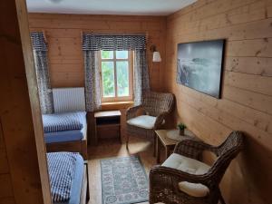 a living room with wicker chairs and a window at Penzion Bouda Na stráni in Dolní Malá Úpa