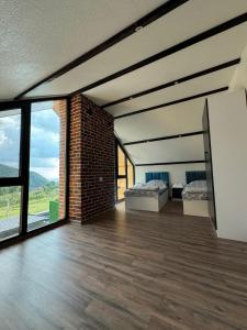 a large room with two beds and a brick wall at Harmony Escape in İsmayıllı
