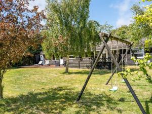 a swing set in the yard of a house at Holiday Home Gerwin - 3km from the sea by Interhome in Blokhus