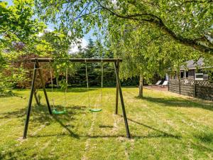 a swing set in a yard with a tree at Holiday Home Gerwin - 3km from the sea by Interhome in Blokhus +16 photos