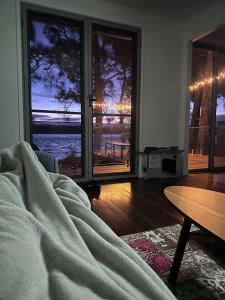 a room with a bed and a view of the ocean at Jerrinja - Absolute waterfront with jetty - 5 mins to Hyams Beach in Erowal Bay