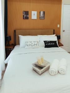 ein weißes Bett mit Handtüchern und Büchern darauf in der Unterkunft Hannah's Place in Davao City